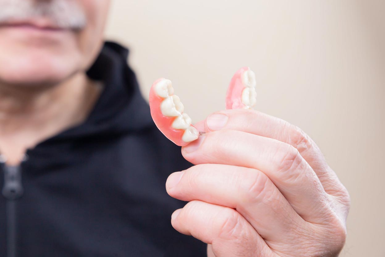 Man Holding Dentures Man Holding Dentures