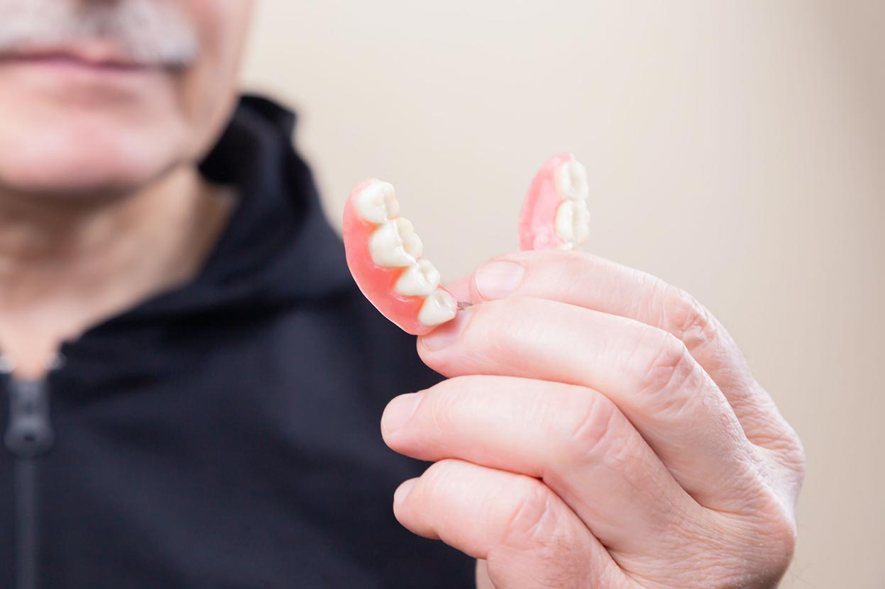 Man Holding Dentures