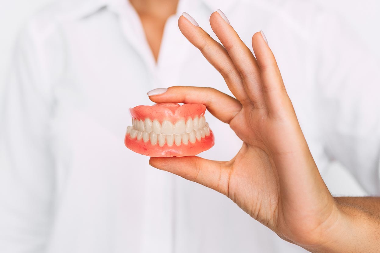 Woman holding dentures